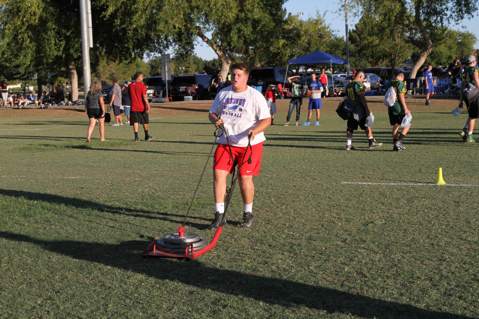 Football player mows the field lawn